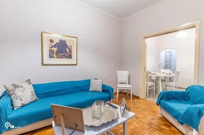 a living room with a blue couch and a table at Sophocles - Central Athenian Cozy Retreat in Athens