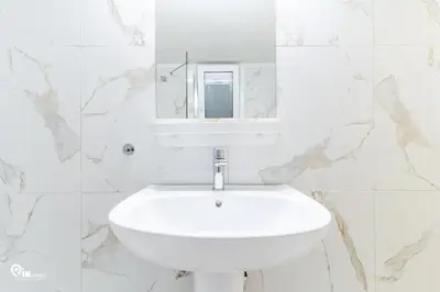 a white bathroom with a sink and a mirror at Sophocles - Central Athenian Cozy Retreat in Athens