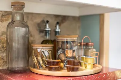 a shelf with a glass bottle and cups on it at DP Homes Exarcheia 1B in Athens