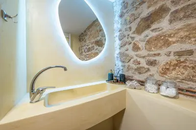 a bathroom with a sink and a stone wall at DP Homes Exarcheia 1B in Athens