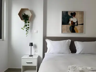 a bedroom with a bed with a painting on the wall at TH0 Luxury two bedrooms Apartments with High-Tech Amenities in Athens