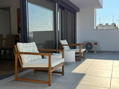 a living room with two chairs and a table at TH0 Luxury two bedrooms Apartments with High-Tech Amenities in Athens