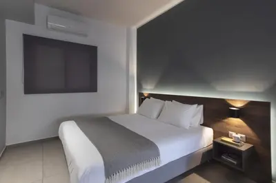 a bedroom with a white bed and a flat screen tv at Renovated 3BDR Apartment in the heart of Athens in Athens