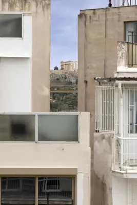 a view of two buildings from a window at Renovated 3BDR Apartment in the heart of Athens in Athens