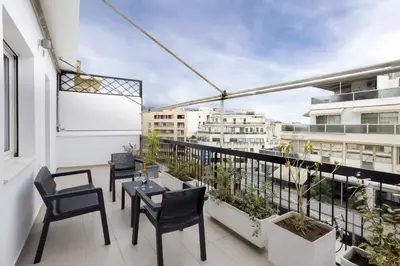 a balcony with chairs and tables on a building at Renovated 3BDR Apartment in the heart of Athens in Athens
