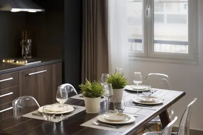 a dining table with glasses and plates and chairs at Renovated 3BDR Apartment in the heart of Athens in Athens