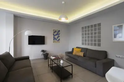 a living room with a couch and a tv at Renovated 3BDR Apartment in the heart of Athens in Athens