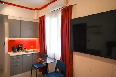 a room with a kitchen with a table and a television at Plaka Suite Next to Acropolis by Zeus Suites in Athens