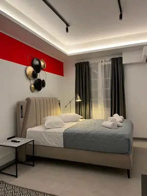 a bedroom with a bed and a red wall at Muses Suite Klathmonos by Zeussuites in Athens