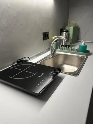 a laptop sitting on a kitchen counter next to a sink at Muses Suite Klathmonos by Zeussuites in Athens