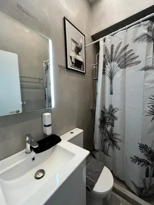 a bathroom with a white sink and a shower curtain at Muses Suite Klathmonos by Zeussuites in Athens