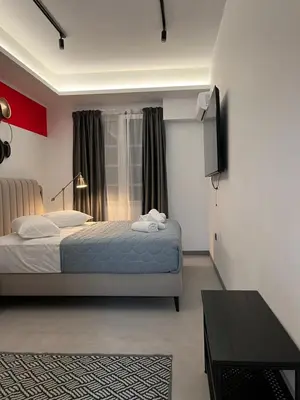 a bedroom with a bed and a flat screen tv at Muses Suite Klathmonos by Zeussuites in Athens