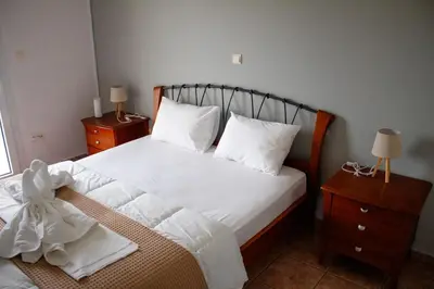 a bedroom with a bed with white sheets and pillows at EMVI APARTMENTS VI near airport in Vravrona