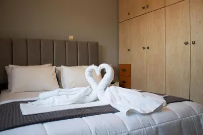 two swans wrapped in towels sitting on a bed at EMVI APARTMENTS VI near airport in Vravrona