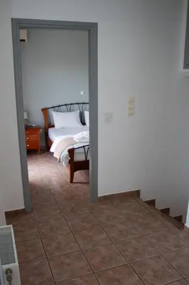 a bedroom with a bed and a tiled floor at EMVI APARTMENTS VI near airport in Vravrona