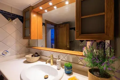 a bathroom with a sink and a mirror at AIOLOS HABITAT pagrati apartment ATHENS in Athens