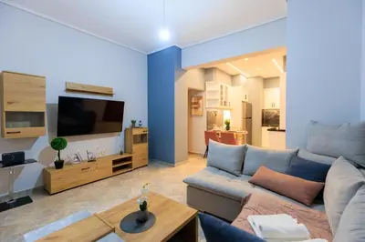 a living room with a couch and a tv at AIOLOS HABITAT pagrati apartment ATHENS in Athens