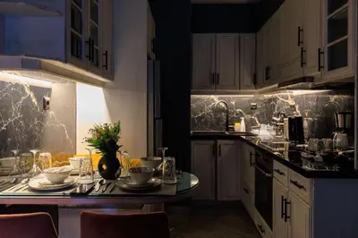 a kitchen with a table with dishes on it at AIOLOS HABITAT pagrati apartment ATHENS in Athens