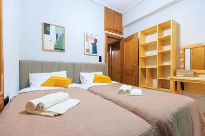 two beds with towels on them in a bedroom at AIOLOS HABITAT pagrati apartment ATHENS in Athens