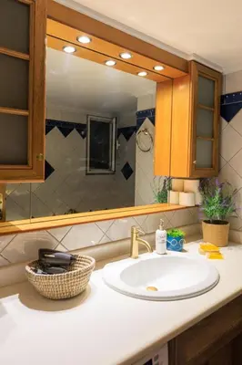 a bathroom with a sink and a mirror at AIOLOS HABITAT pagrati apartment ATHENS in Athens