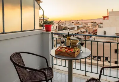 a table with a box of food and wine on a balcony at Urban cozy penthouse with city view in Athens