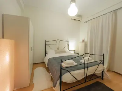 a bedroom with a bed with a black metal frame at Urban cozy penthouse with city view in Athens