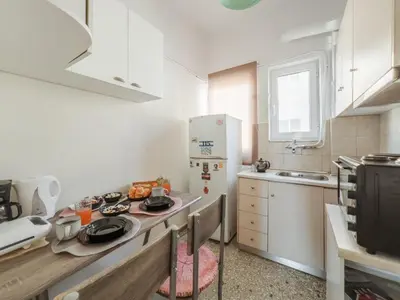 a small kitchen with a counter top and a refrigerator at Urban cozy penthouse with city view in Athens