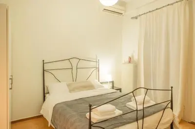 a white bedroom with a bed with a metal frame at Urban cozy penthouse with city view in Athens