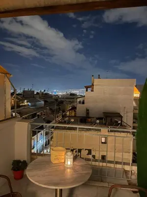 a table on a balcony with a view of a city at Urban cozy penthouse with city view in Athens