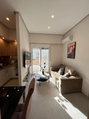 a living room with a couch and a table at Stylish Condo Nearby Acropolis & Metro in Athens