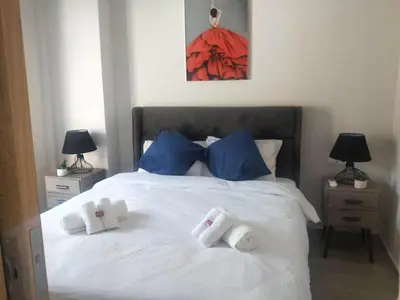 a bedroom with a white bed with blue pillows at Stylish Condo Nearby Acropolis & Metro in Athens