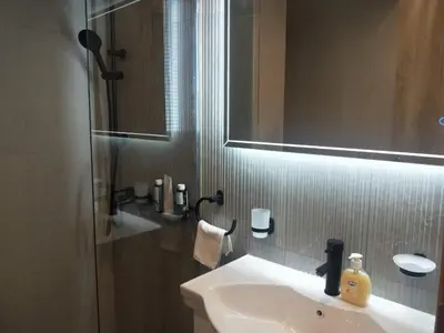 a bathroom with a sink and a mirror and a shower at Stylish Condo Nearby Acropolis & Metro in Athens