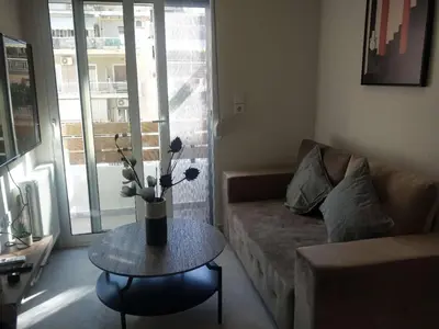 a living room with a couch and a table with flowers on it at Stylish Condo Nearby Acropolis & Metro in Athens