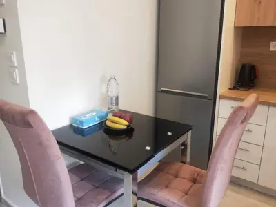 a table with two pink chairs and a table with a bottle of water and bananas at Stylish Condo Nearby Acropolis & Metro in Athens