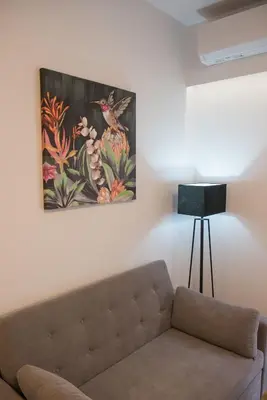 a living room with a couch and a painting on the wall at Arie Central Apartments by Live & Travel in Athens