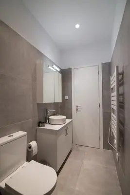 a bathroom with a white toilet and a sink at Arie Central Apartments by Live & Travel in Athens