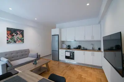 a kitchen and living room with a couch and a table at Arie Central Apartments by Live & Travel in Athens