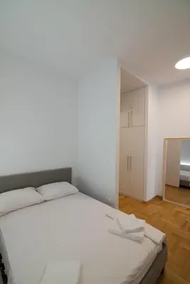 a bedroom with a large white bed and a mirror at Arie Central Apartments by Live & Travel in Athens