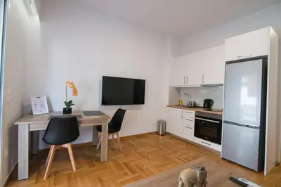 a small kitchen with a table and a refrigerator at Arie Central Apartments by Live & Travel in Athens