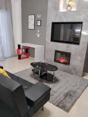 a living room with a couch and a fireplace at Elegant Minimalistic Downtown Apartment! in Athens