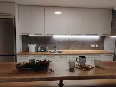 a kitchen with white cabinets and a wooden table at Elegant Minimalistic Downtown Apartment! in Athens
