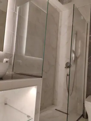 a shower with a glass door in a bathroom at Elegant Minimalistic Downtown Apartment! in Athens