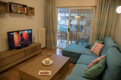 a living room with a blue couch and a tv at Little Acropolis in Athens