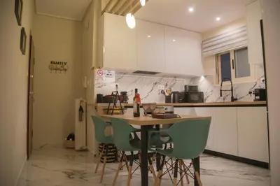 a kitchen with a table and green chairs at Little Acropolis in Athens