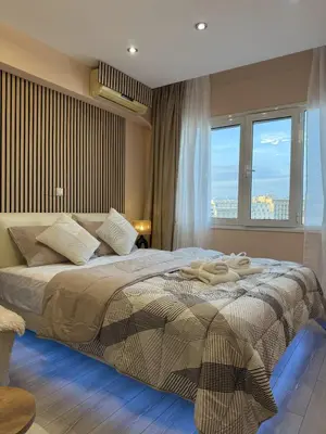 a bedroom with a large bed with a large window at Heart of Athens, right next to Syntagma Square in Athens