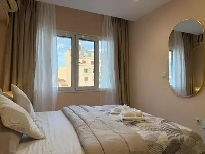 a bedroom with a bed with a mirror and a window at Heart of Athens, right next to Syntagma Square in Athens