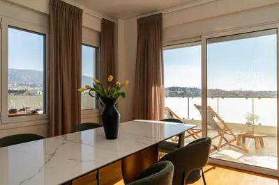 a kitchen with a table with chairs and a large window at Elegant Skyline Penthouse Acropolis View 3BR 2BA in Athens