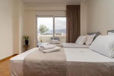 two beds in a hotel room with a window at Elegant Skyline Penthouse Acropolis View 3BR 2BA in Athens