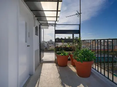 a balcony with pots of plants on a building at Athens at your feet - Modern Loft with a view in Athens