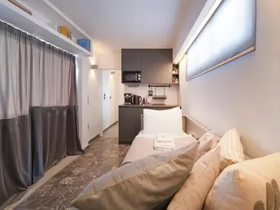 a small room with a couch and a kitchen at Athens at your feet - Modern Loft with a view in Athens